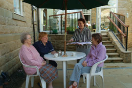 Ashcroft House residents and staff sat talking outside at a patio table
